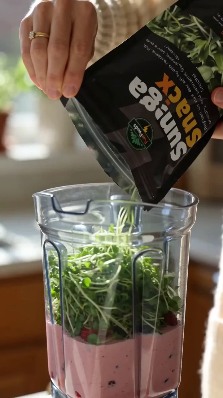 FuelFoods microgreens being poured into a berry smoothie